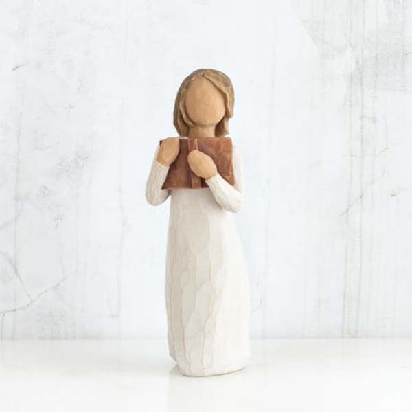 Wooden figurine of a girl holding a book