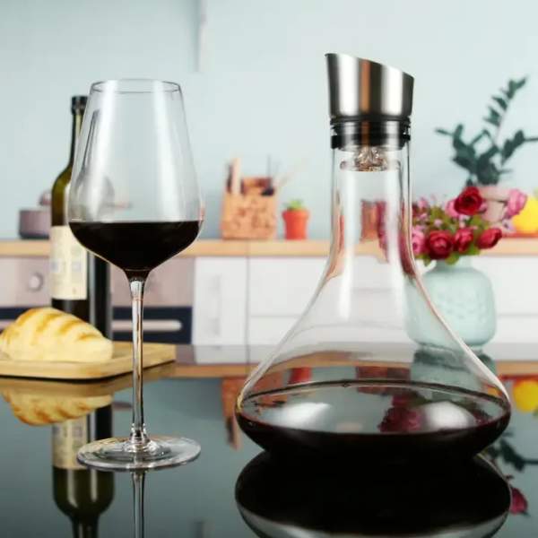 Wine glass and decanter with red wine beside bread and flowers