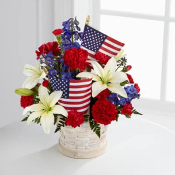 Red, white, and blue floral arrangement in a basket with American flags