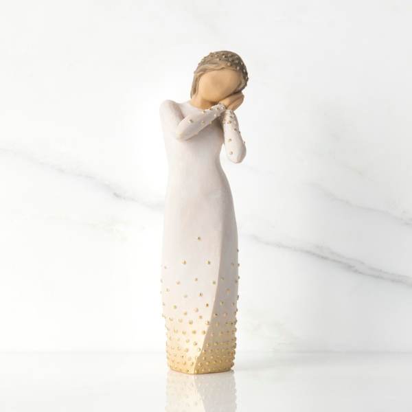 Decorative figurine of a woman in a long cream dress with gold accents