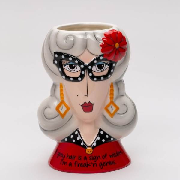Decorative ceramic planter shaped like a woman’s face with gray hair and a red flower