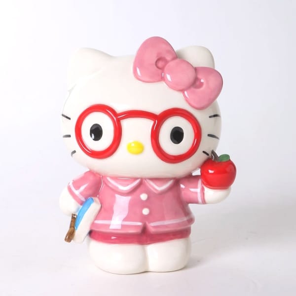 Hello Kitty figurine in pink outfit holding an apple