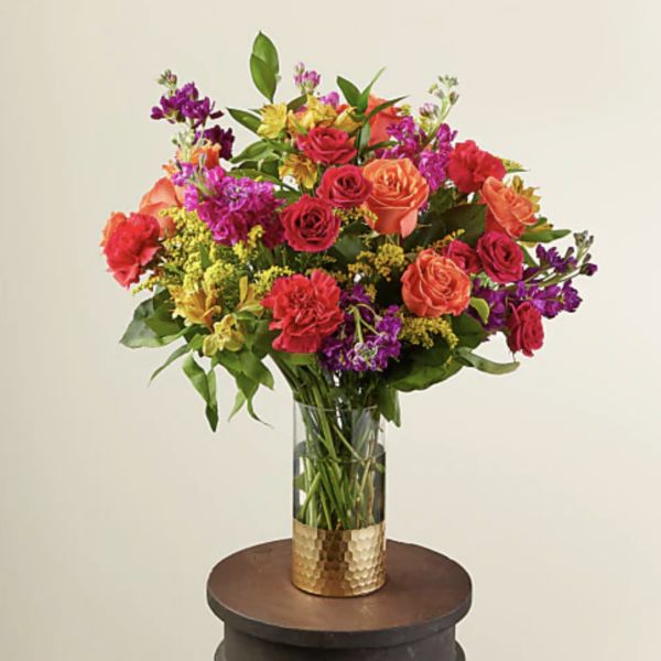Mixed bouquet of roses and other flowers in a glass vase
