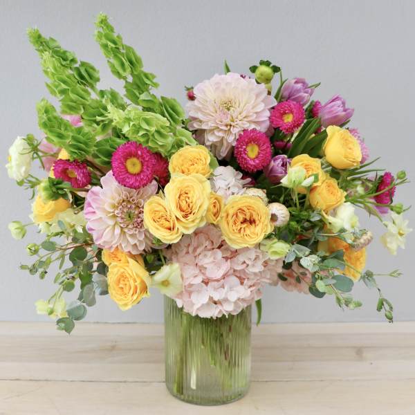 Mixed bouquet of yellow and pink flowers in a glass vase