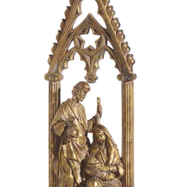 Gold-toned religious figurine under a Gothic arch