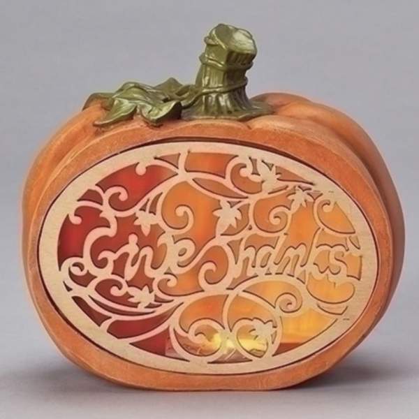 Decorative pumpkin-shaped candle holder with a carved "Happy Halloween" panel