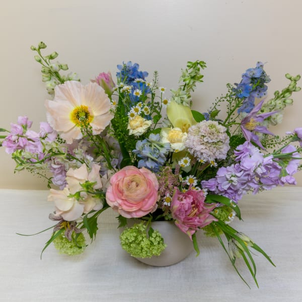 Pastel mixed flower arrangement in a low white vase