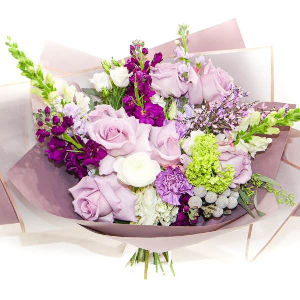 Bouquet of lavender roses and purple flowers wrapped in pink paper