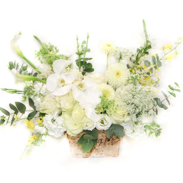 White floral arrangement in a rustic rectangular container