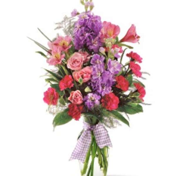 Mixed pink and purple bouquet in a glass vase with a gingham ribbon