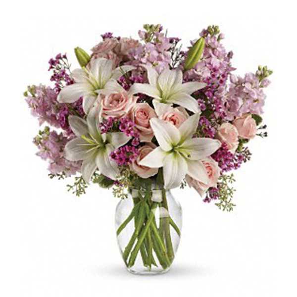 Bouquet of white lilies and pink roses in a clear glass vase