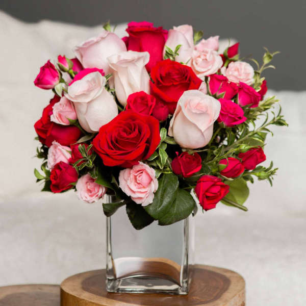 Bouquet of red and pale pink roses in a clear glass vase