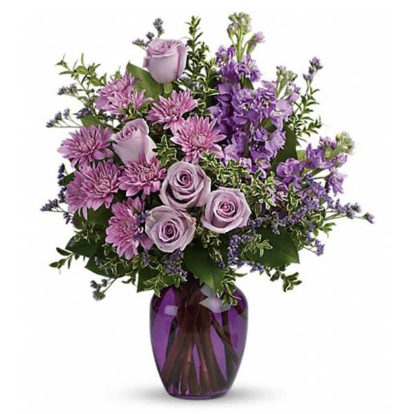 Lavender roses and purple flowers in a purple glass vase