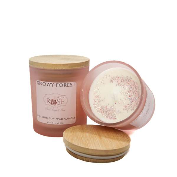 Pink rose-scented candle in a glass jar with a wooden lid