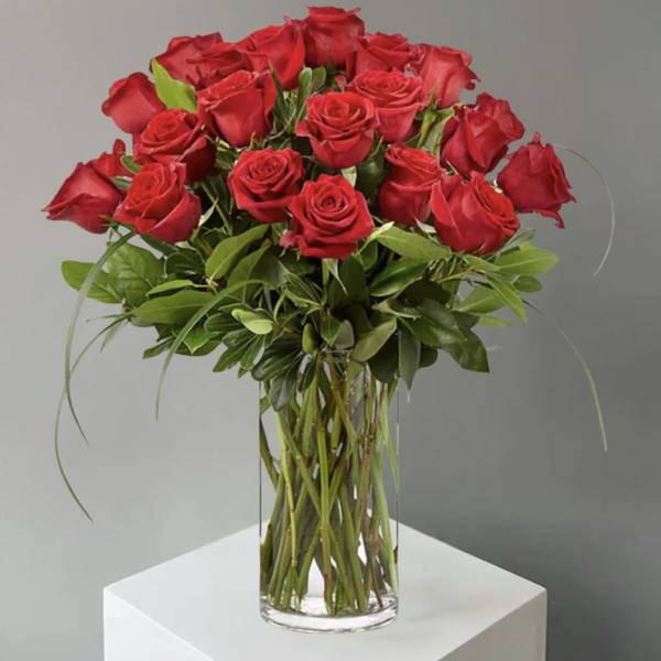Red roses arranged in a clear glass vase