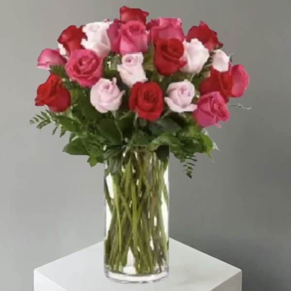 Bouquet of red, pink, and white roses in a clear glass vase