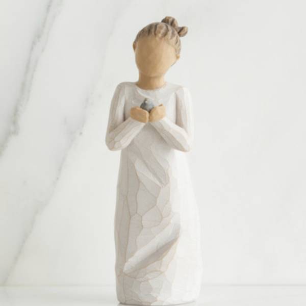 Wooden angel figurine holding a small bird