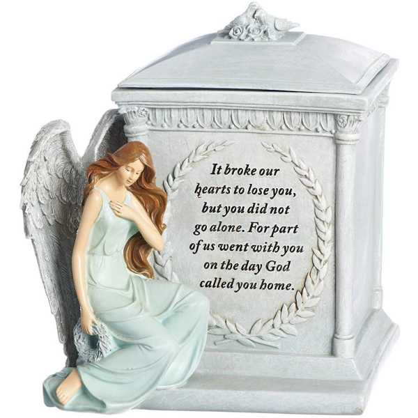 Angel figurine beside a memorial urn with a sympathy message