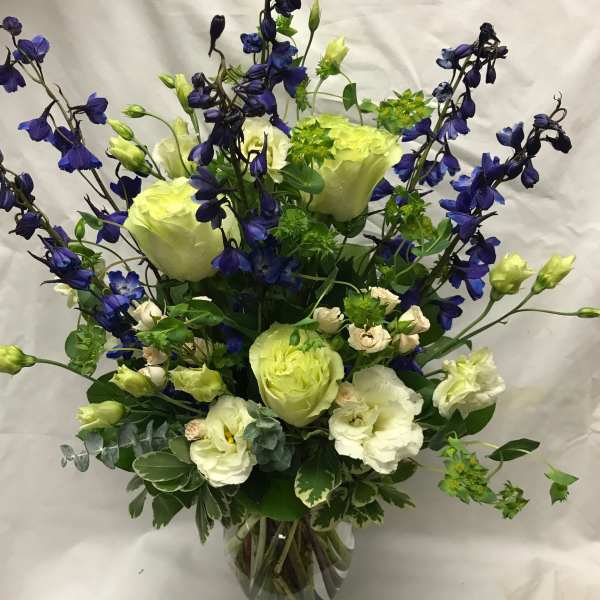 Blue and white floral arrangement in a clear glass vase
