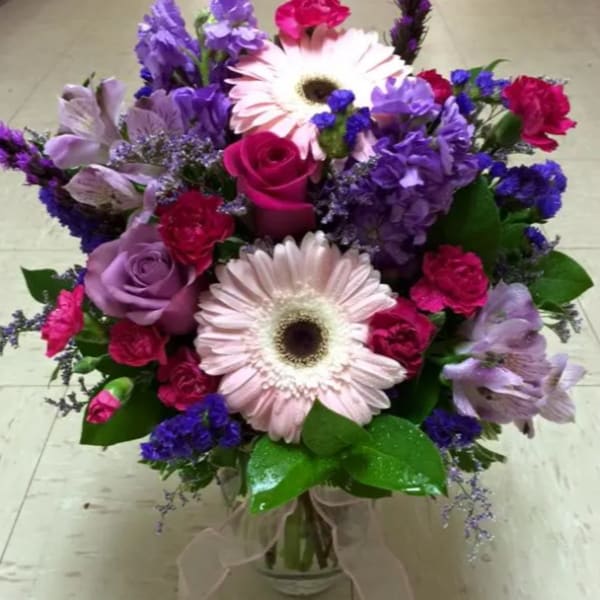 Bouquet of pink and purple flowers in a clear glass vase