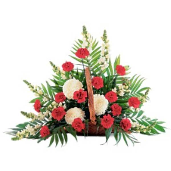 Red and white flower arrangement in a brown wicker basket.