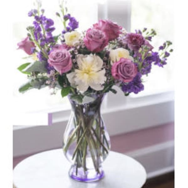 Purple and white bouquet in a clear glass vase