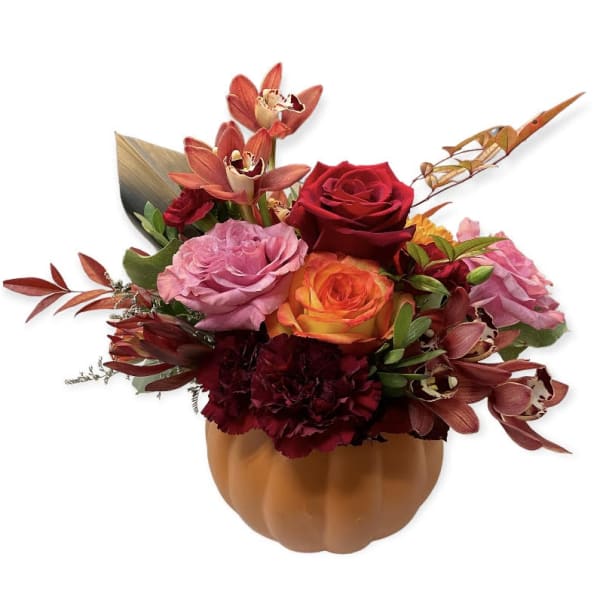 Bouquet of red, pink, and orange flowers in a pumpkin-shaped container