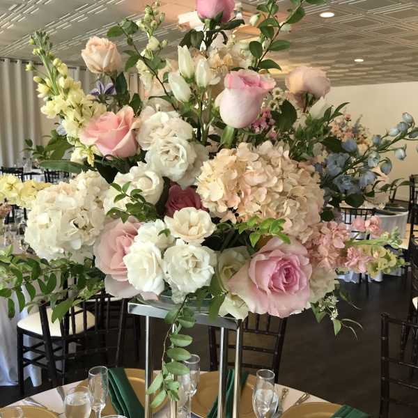 Tall pastel floral centerpiece with pink and white roses and hydrangeas