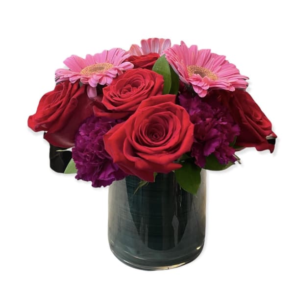 Red roses and pink daisies in a glass vase