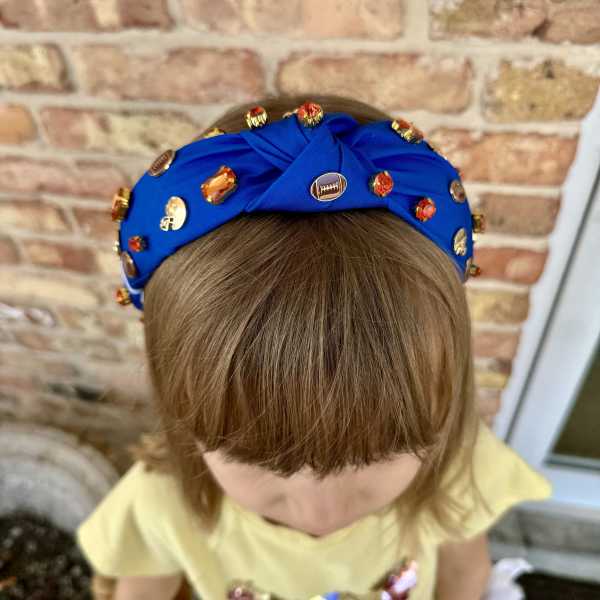 Child wearing a blue jeweled headband