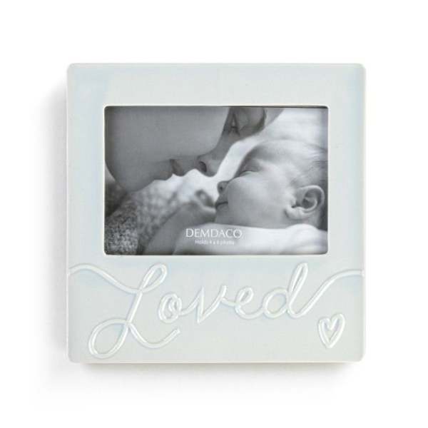 White photo frame with a baby picture and the word Loved