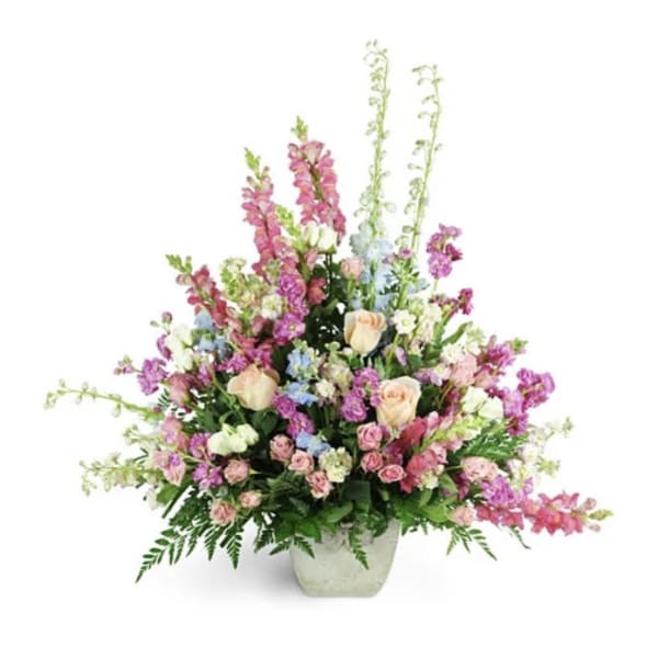 Tall mixed flower arrangement in a white vase