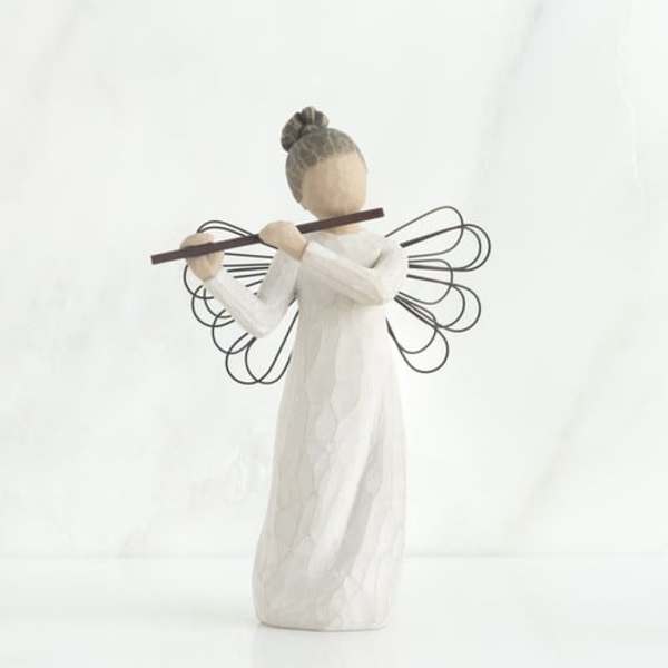 Wooden angel figurine in a white dress holding a flute