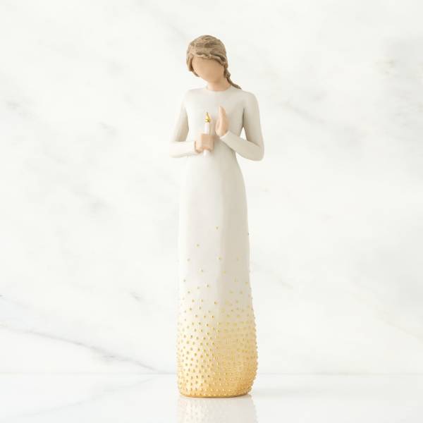 White angel figurine holding a candle