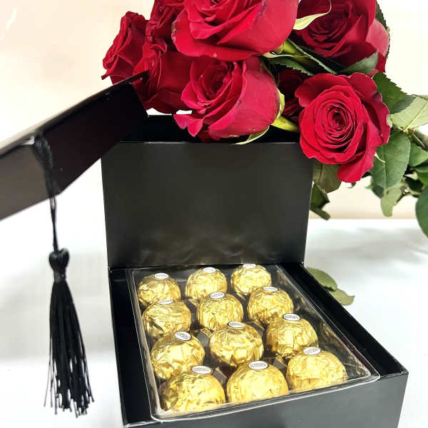 Red roses in a black gift box with gold-wrapped chocolates