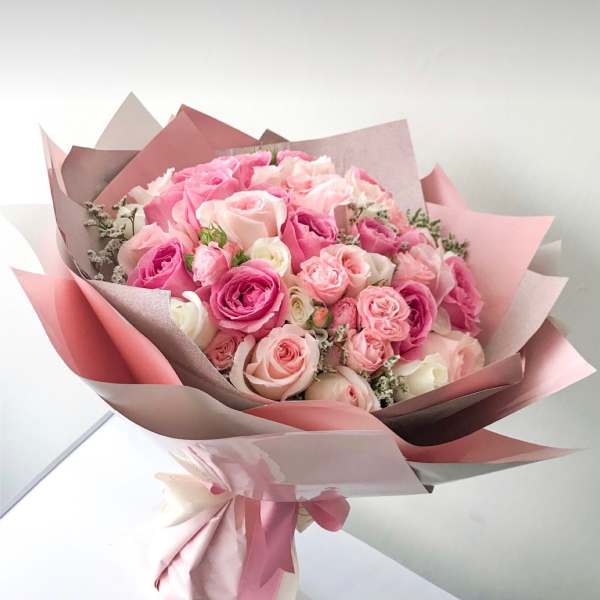 Pink and blush rose bouquet wrapped in layered paper