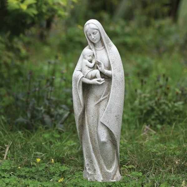 Stone statue of a robed woman holding a child outdoors