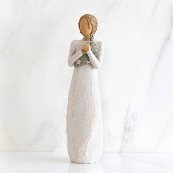 Angel figurine holding a star-patterned cloth