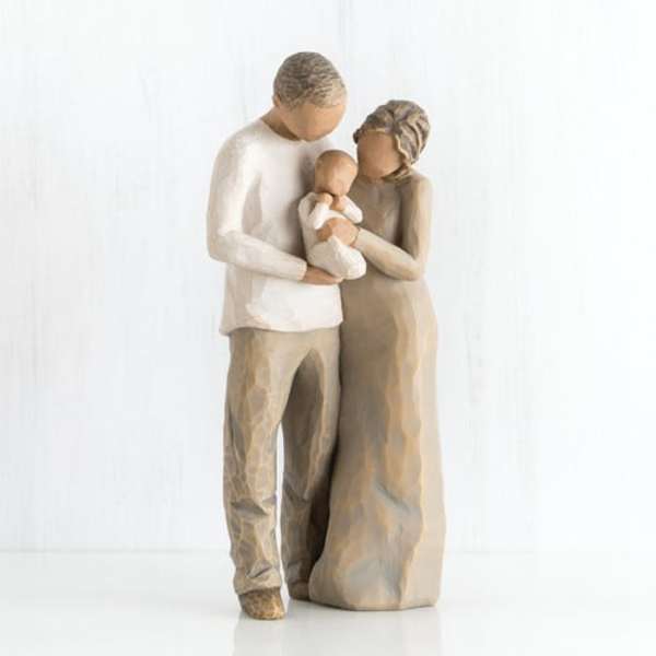 Wooden figurine of a couple holding a baby
