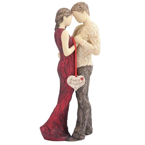Couple figurine holding a heart-shaped anniversary tag