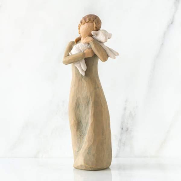 Wooden angel figurine holding a white lamb