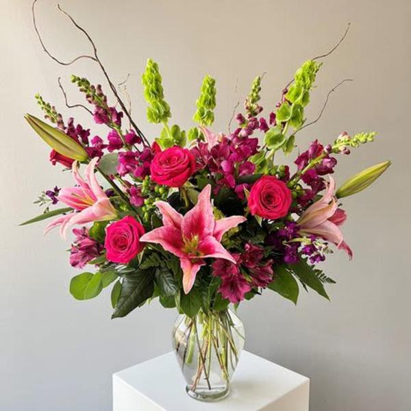 Pink lilies and roses in a clear glass vase