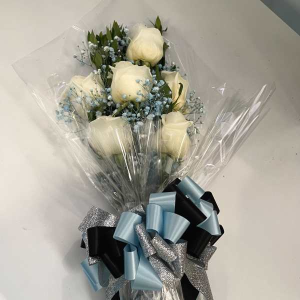 Bouquet of white roses with blue filler flowers wrapped in clear plastic