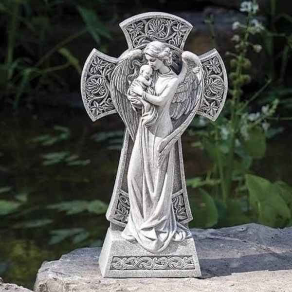 Stone angel figurine holding a child on a rock outdoors