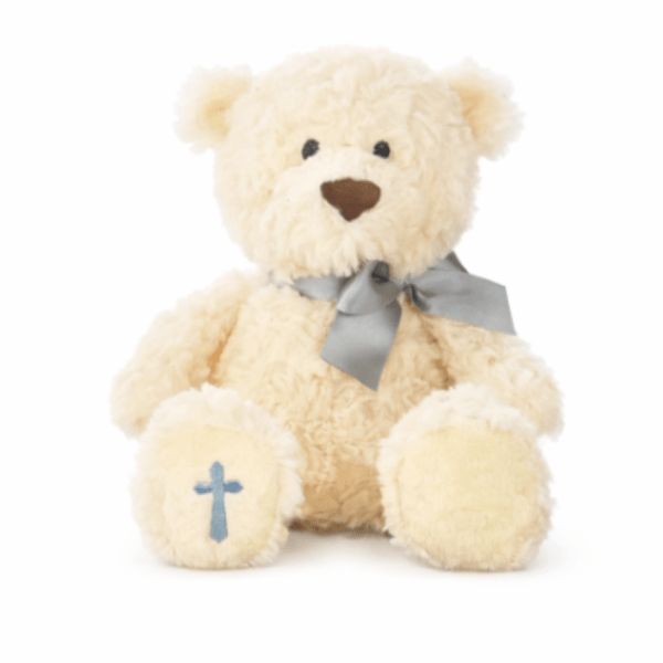 Cream plush teddy bear with a gray bow and a blue cross on one paw.
