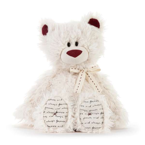 White teddy bear with a ribbon bow on a plain background