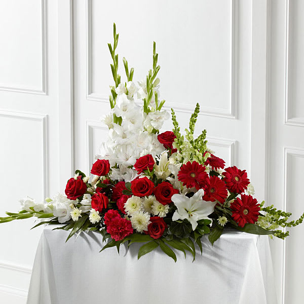 Red and white floral arrangement with roses, lilies, and tall white blooms