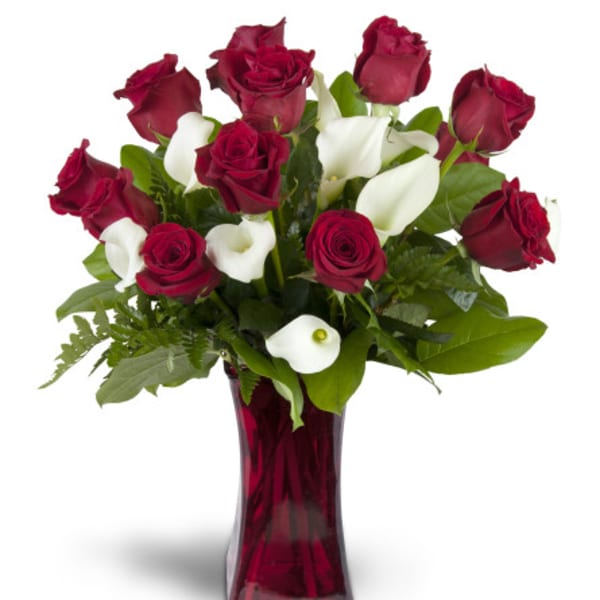 Red roses and white calla lilies in a red glass vase
