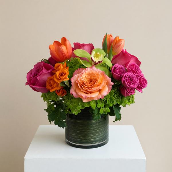 Colorful bouquet of roses and tulips in a dark green vase
