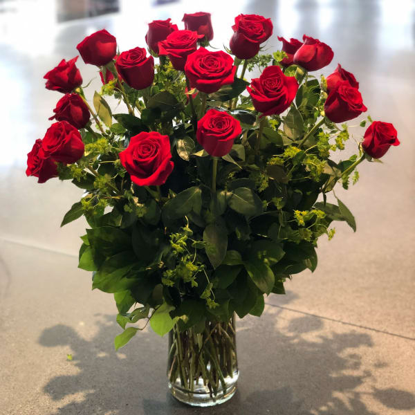 Red roses arranged in a clear glass vase